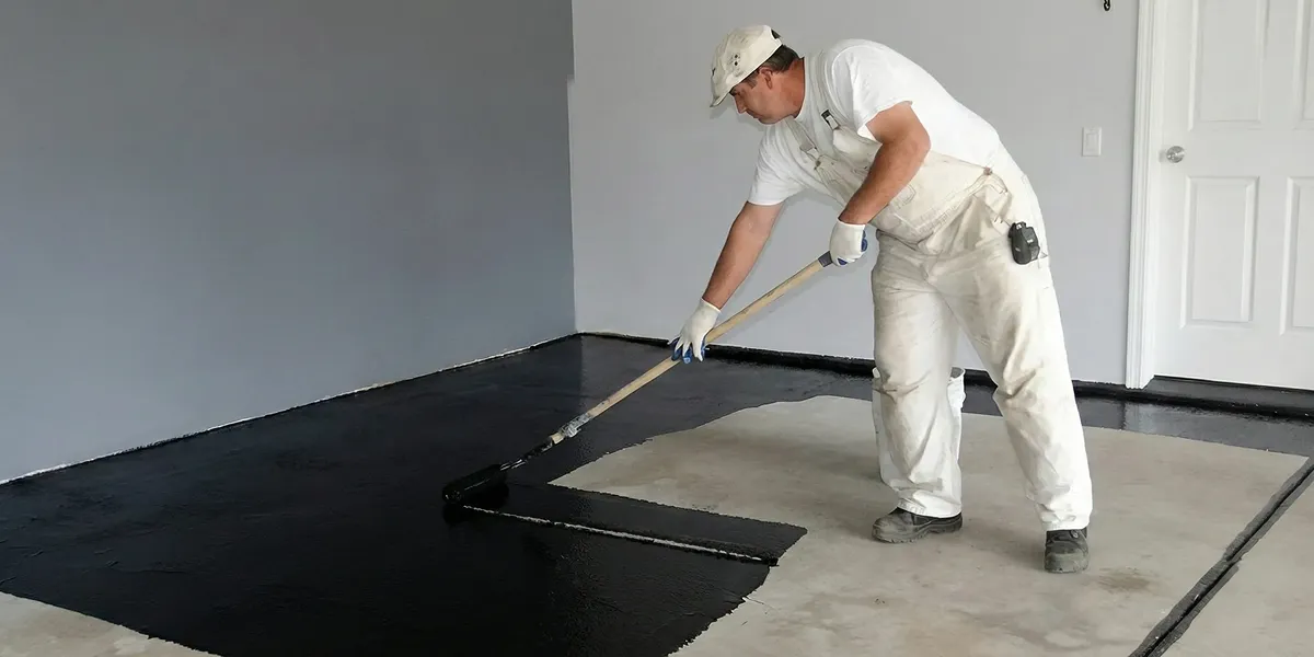 basement waterproofing professional applying waterproof coating to protect a basement floor in Boca Raton, FL